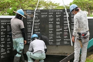 　石碑「平和の礎」に刻銘板を設置する作業員＝１８日午前、沖縄県糸満市摩文仁の平和祈念公園