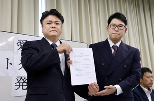 　経営者らが署名した誓約書を持つ「愛知県ホストクラブ協議会」の山本洸嗣代表（左）ら＝１８日午後、名古屋市