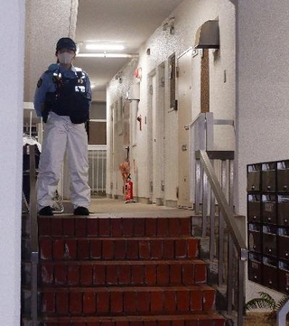 　冷凍庫に入った男性の遺体が見つかった集合住宅を警戒する警察官＝２０日午後９時２６分、神戸市中央区