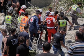 　２０日、レバノン南部でイスラエルによる空爆で破壊された建物の下から見つかった被害者を搬送する人たち（ＡＰ＝共同）