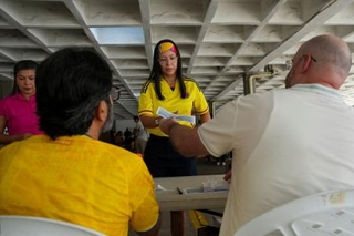 　コロンビア大統領選の決選投票の用紙を有権者に手渡す担当者＝２１日、バランキジャ（ロイター＝共同）