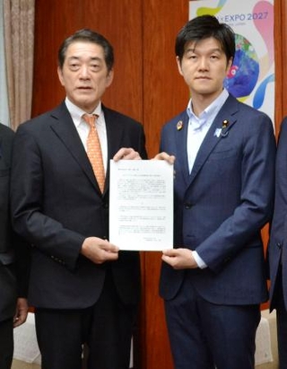 　鈴木農相（右）に実態解明などの要望書を手渡す中村時広愛媛県知事＝２２日午前、農水省