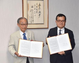　全国大学生協連と連携協定書を交わした「ノーモア・ヒバクシャ記憶遺産を継承する会」の浜住治郎さん（左）＝２２日午後、東京都杉並区