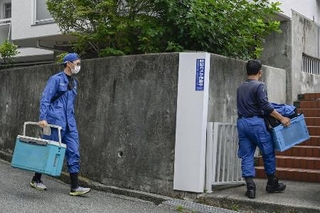 　大型冷凍庫から成人男性の遺体が見つかったマンションに出入りする捜査員＝２２日午前、神戸市中央区