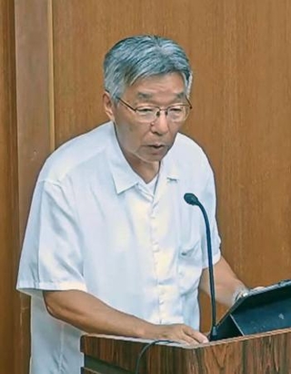 　東京都小笠原村議会で答弁する渋谷正昭村長＝２４日午後（議会の中継映像から）