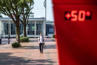 　２６日、熱波に見舞われたドイツ西部ドルトムントで、温度計の前を歩く男性（ゲッティ＝共同）