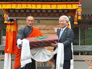 　ブータンのトブゲイ首相（左）から記念品を贈られるＪＩＣＡの田中明彦理事長＝２８日、ギダコム（共同）