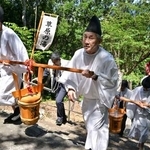 　山神社で営まれた「献湯祭」で、朝一番の源泉からくみ上げた「一番湯」を運ぶ関係者ら＝１日午前、和歌山県白浜町