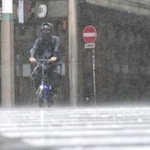 　台風６号の影響で雨が強まる中、自転車で走る男性＝２日午後、宮崎市