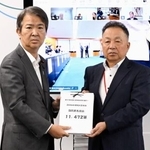 　石原環境相（左）に署名を手渡す「全国公害被害者総行動実行委員会」のメンバー＝３日午前、環境省