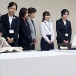 　原爆死没者名簿に記帳する中本信子さん（手前左）と大川純子さん。後方は一般公募で選ばれた記帳者ら＝４日午前、広島市役所