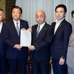 　国民投票法改正案を衆院の築山信彦事務総長（中央）に提出する自民党の新藤義孝氏（左から２人目）ら４党の議員＝５日午後、国会