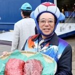 　ナガスクジラの肉を手にする共同船舶の所英樹社長＝８日午前、仙台市