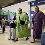 　大相撲パリ公演に向け、フランスのシャルル・ドゴール空港に到着した大関霧島（左）ら＝９日、パリ近郊（共同）