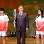 　愛知・名古屋アジア大会の開幕まで１００日となり、セレモニーで聖火リレーのユニホーム（左右）とともにトーチを披露する松平健さん＝１１日午前、名古屋市
