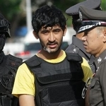 　警察官に付き添われるユスフ・マイライリ被告（中央）＝２０１５年９月、タイ首都バンコク（ＡＰ＝共同）