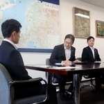 　福井県の坂本裕一郎防災安全部長（左）と面会する関西電力の高畠勇人原子力事業本部長代理（中央）＝１２日午後、福井県庁