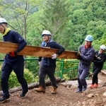 　日航ジャンボ機墜落事故から４１年となるのを前に、登山道整備に使う丸太を運ぶ群馬県警藤岡署の有志署員＝１３日午前、群馬県上野村