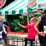 　「富里スイカロードレース」で、スイカを食べるランナー＝１４日午前、千葉県富里市