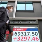 　初めて６万９０００円を突破して最高値を更新した日経平均株価終値を示すモニター＝１５日午後、東京都中央区