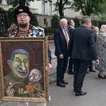 　１２日、ドイツ・ベルリンのロシア大使館前でプーチン氏の風刺画を掲げるセミョーン・スクレペツキー氏（同氏のテレグラムから・共同）