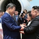 　平壌国際空港に到着した中国の習近平国家主席（手前左）を出迎える北朝鮮の金正恩朝鮮労働党総書記＝８日（新華社＝共同）