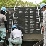 　石碑「平和の礎」に刻銘板を設置する作業員＝１８日午前、沖縄県糸満市摩文仁の平和祈念公園