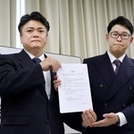 　経営者らが署名した誓約書を持つ「愛知県ホストクラブ協議会」の山本洸嗣代表（左）ら＝１８日午後、名古屋市