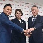 　ポーズをとるアイスホッケー女子日本代表の大久保智仁新監督（右）と、久保英恵新コーチ（中央）ら＝１９日、東京都内
