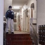 　冷凍庫に入った男性の遺体が見つかった集合住宅を警戒する警察官＝２０日午後９時２６分、神戸市中央区