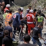 　２０日、レバノン南部でイスラエルによる空爆で破壊された建物の下から見つかった被害者を搬送する人たち（ＡＰ＝共同）