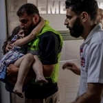 　２０日、レバノン南部の病院で、イスラエルによる攻撃で負傷した少女を搬送する人（ロイター＝共同）