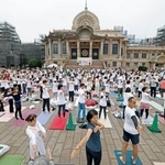 　国連が定めた「国際ヨガの日」に、東京都中央区の築地本願寺の境内でヨガを楽しむ参加者＝２１日午前