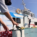 　魚島に向かう船に生活用品を積み込む利用客＝５月、愛媛県上島町の弓削港