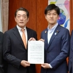 　鈴木農相（右）に実態解明などの要望書を手渡す中村時広愛媛県知事＝２２日午前、農水省