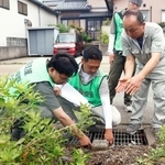 　土地家屋調査士と土地の境界を確認する中居正樹さん（右端）＝２２日午前、石川県内灘町