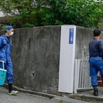 　大型冷凍庫から成人男性の遺体が見つかったマンションに出入りする捜査員＝２２日午前、神戸市中央区