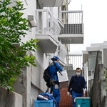 　大型冷凍庫から成人男性の遺体が見つかったマンションに出入りする捜査員＝２２日午前、神戸市中央区