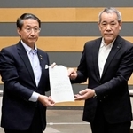 　中国電力から島根原発２号機のプルサーマル発電についての文書を受け取る平井伸治鳥取県知事（左）＝２４日午前、鳥取県境港市
