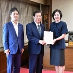 　提言を受け取る平口法相（中央）。右は日本維新の会の三木圭恵衆院議員＝２６日午前、法務省