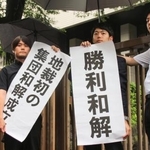 　建設石綿訴訟の和解成立後、「勝利和解」などと書かれた紙を掲げる弁護団＝２６日午後、東京地裁前