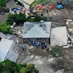 　土砂崩れに巻き込まれた山口県平生町の住宅で、捜索と救助に当たる警察官ら＝２７日午前１１時３９分（共同通信社ヘリから）