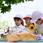 　沖縄県うるま市の宮森小で献花する児童たち＝３０日午前