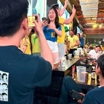 　中国上海市のスポーツバーで、漫画「キャプテン翼」のイラストが描かれたＴシャツを着て、勝利を喜ぶブラジルファンを見つめる男性＝３０日（共同）