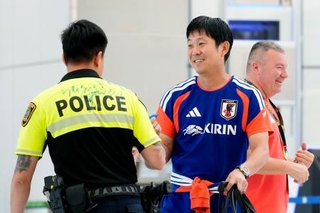 　ヒューストンの空港に到着し、警察官の背中にサインした森保監督（右）＝１日（共同）