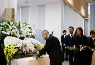 　２０２０年７月の豪雨の追悼式で献花する参列者＝５日午前、熊本県人吉市