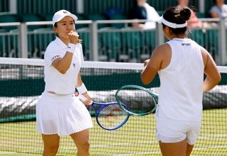 　女子ダブルス３回戦でポイントを奪い、ガッツポーズする青山修子。右は梁恩碩＝ウィンブルドン（共同）