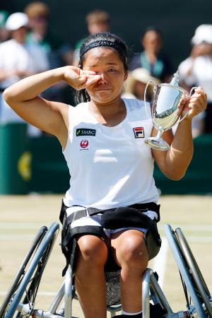 　車いすの部女子シングルスで優勝し、トロフィーを手に涙ぐむ上地結衣。「生涯ゴールデンスラム」を日本女子として初めて達成した＝ウィンブルドン（共同）