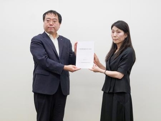 　厚労省の担当者（右）に要望書を手渡す長崎県の新田惇一福祉保健部長＝１５日午後、厚労省