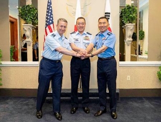 　１５日、米国で記念撮影する内倉浩昭統合幕僚長（中央）、米軍のケイン統合参謀本部議長（左）、韓国軍の陳永承合同参謀本部議長（防衛省統合幕僚監部提供）